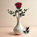 Image of a single red rose template in wood and completed with cross stitch embroidery in a white vase. A real red rose is laying to the side.