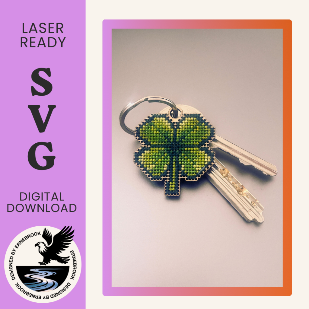 Image of a four-leaf clover key-fob template in wood and completed with cross stitch embroidery attached to a bunch of keys. To the left is a purple panel with the words Laser ready SVG digital download with the logo of Ernebrook Designs of an Eagle flying above a brook.